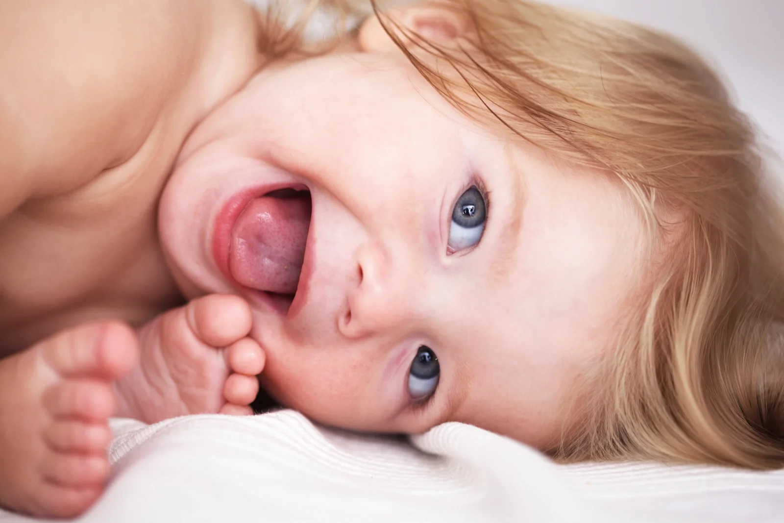 Toddler lying on a white blanket